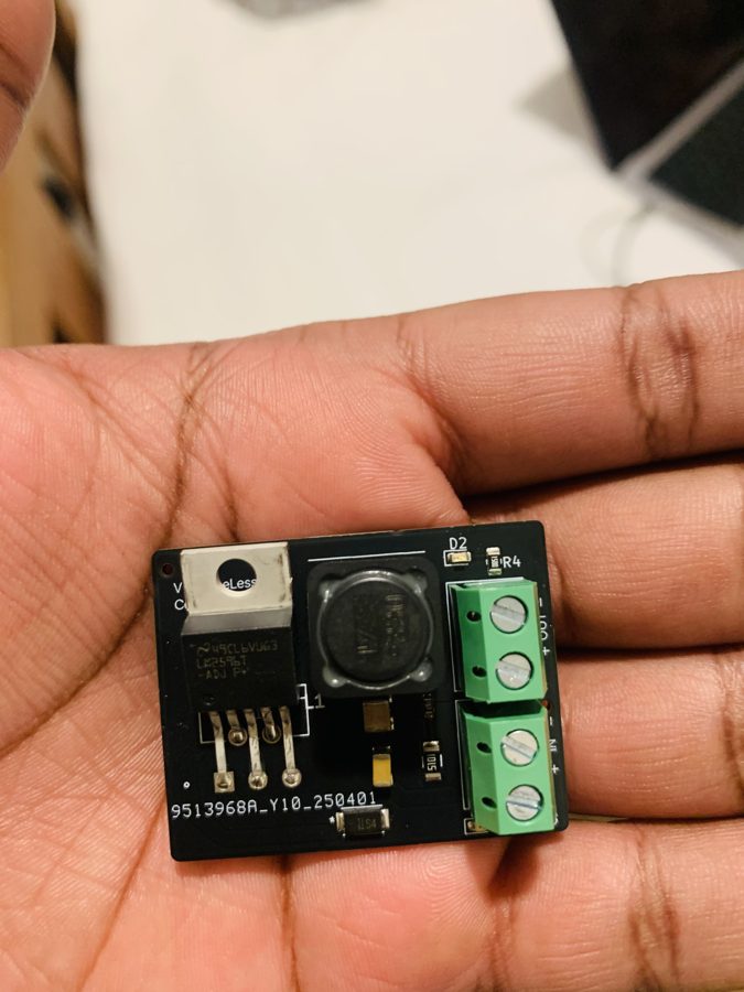 DC Converter v1.0 flat in a palm, regulator and IN/OUT terminal blocks visible